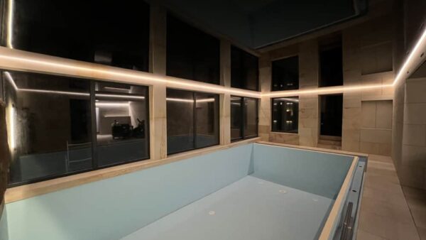 Lesklý černý napínaný strop v bazénu rodinného domu s elegantním LED podsvícením 