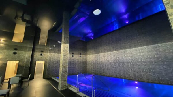Černý lesklý napínaný strop v hotelovém wellness s dokonalým odrazem a ambientním podsvícením 