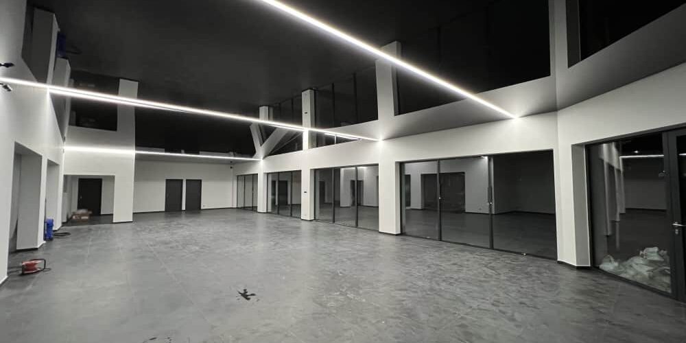 Černý lesklý napínaný strop se světelnou linií – PK Technik s.r.o. Černý lesklý napínaný strop s liniovým LED osvětlením v moderním showroomu společnosti PK Technik s r o