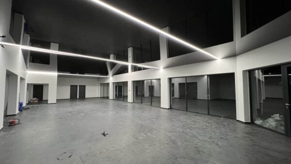 Černý lesklý napínaný strop s liniovým LED osvětlením v moderním showroomu společnosti PK Technik s r o 