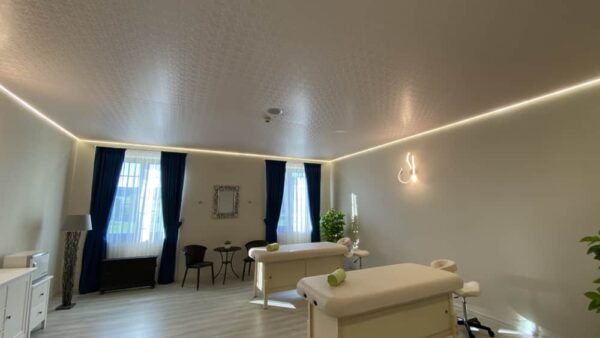 Světlý dekorativní napínaný strop s jemným vzorem a podsvícením v masážní místnosti hotelu Chateau Šanov 