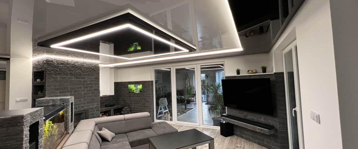 Lesklý napínaný strop s LED osvětlením v obývacím pokoji Moderní obývací pokoj s lesklým napínaným stropem a integrovaným LED osvětlením