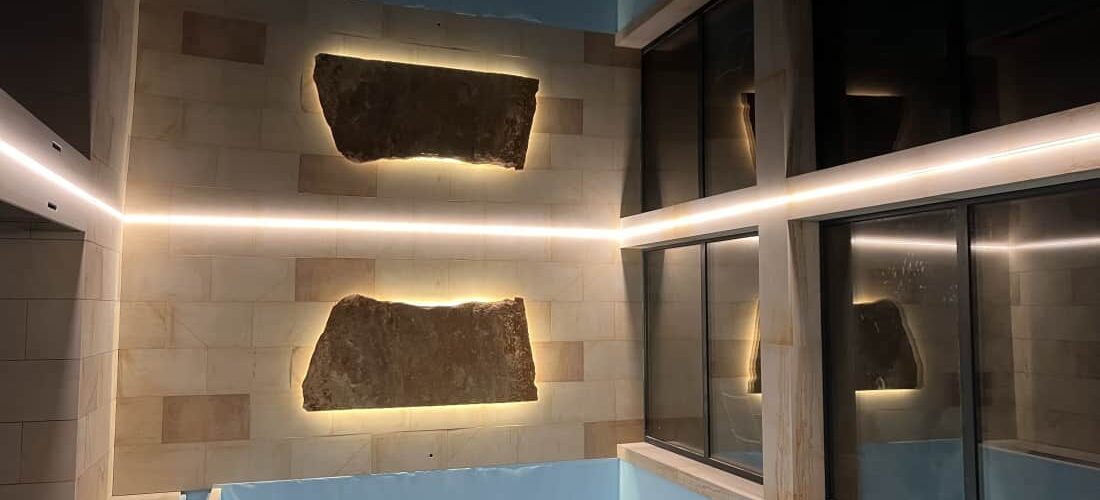 Černý_napínaný_strop_sKamenem Černý napínaný strop v bazénu s LED podsvícením a masivním kamenným prvkem na stěně