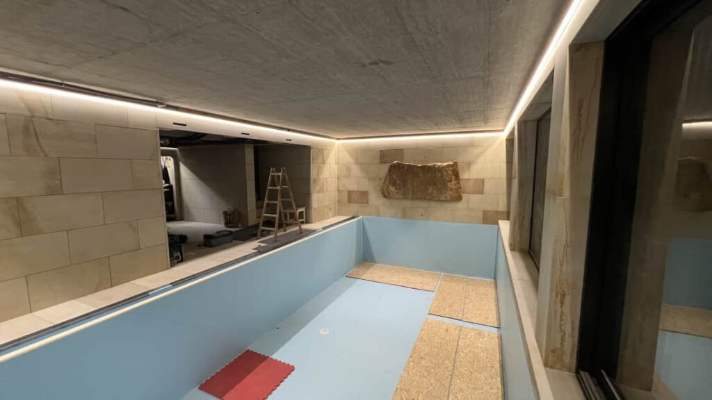 Přípravné práce na instalaci černého napínaného stropu s obvodovým LED osvětlením v bazénu.