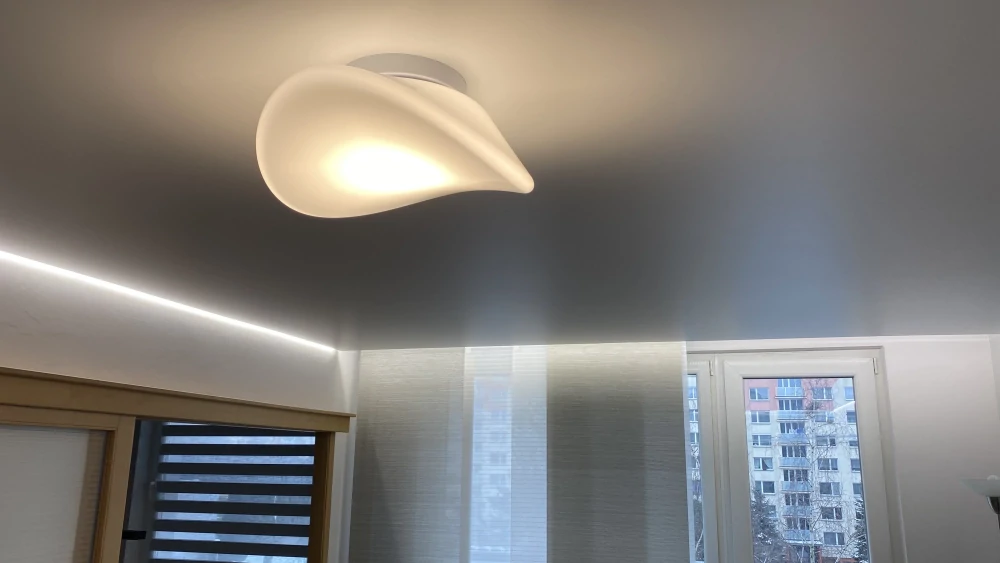 Přisazené osvětlení instalované na napínaném stropu s LED páskem po obvodu.