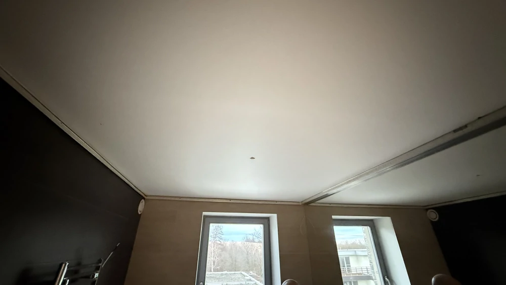 Pohled na bílý matný strop v koupelně připravený pro instalaci světlo propustného napínaného stropu