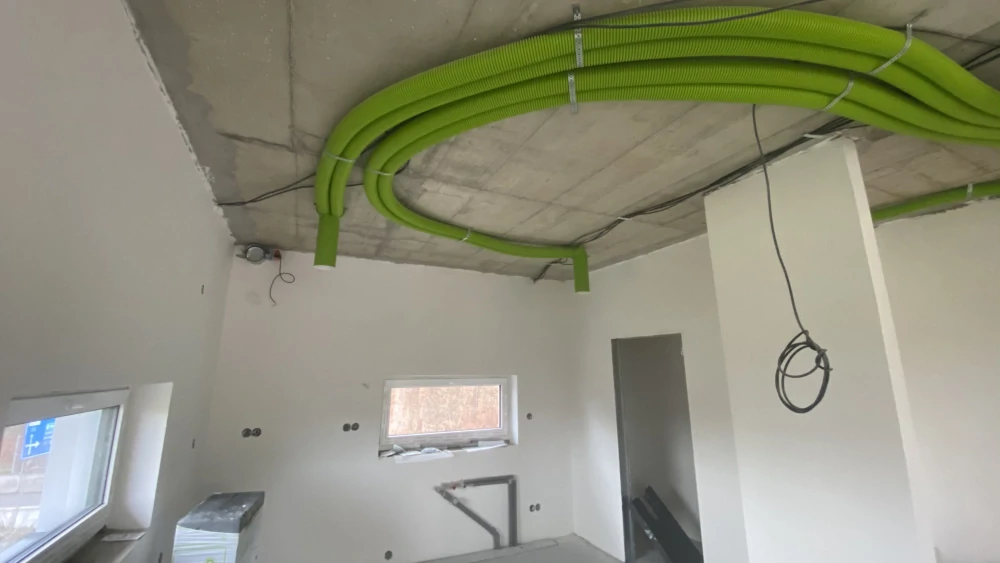 Rozvody zeleného potrubí a kabeláže pod betonovým stropem před instalací napínaného stropu