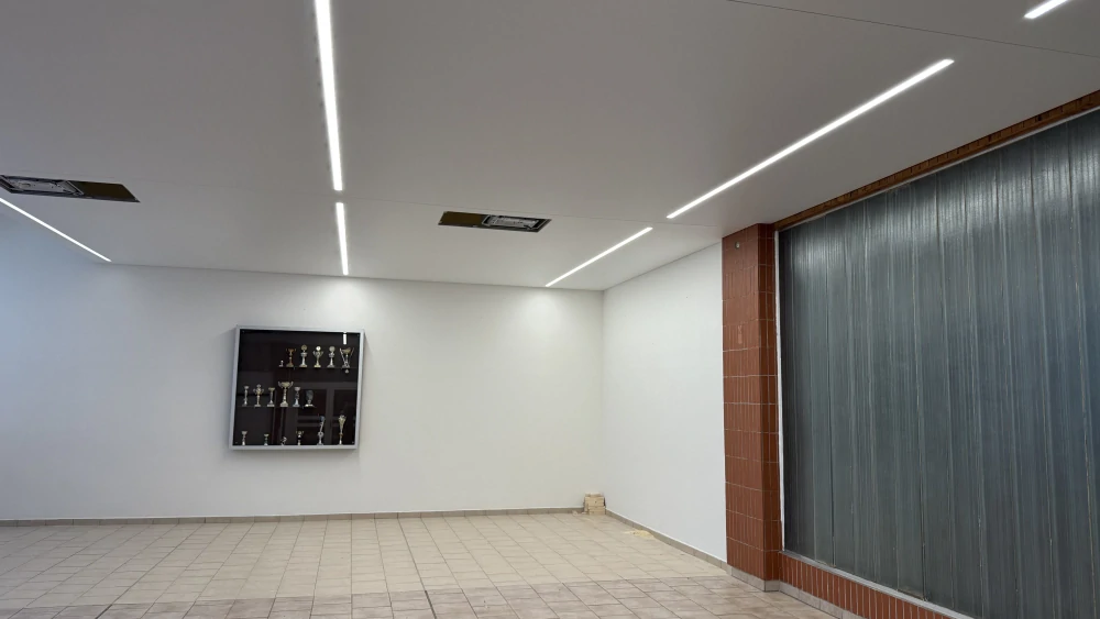 Detailní pohled na integrované světelné LED linie zapuštěné v matném napínaném podhledu.